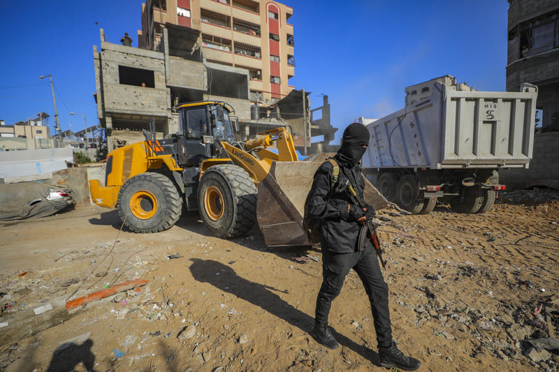 Members of the Qassam Brigades use heavy machinery to search for the bodies of Israeli hostages.