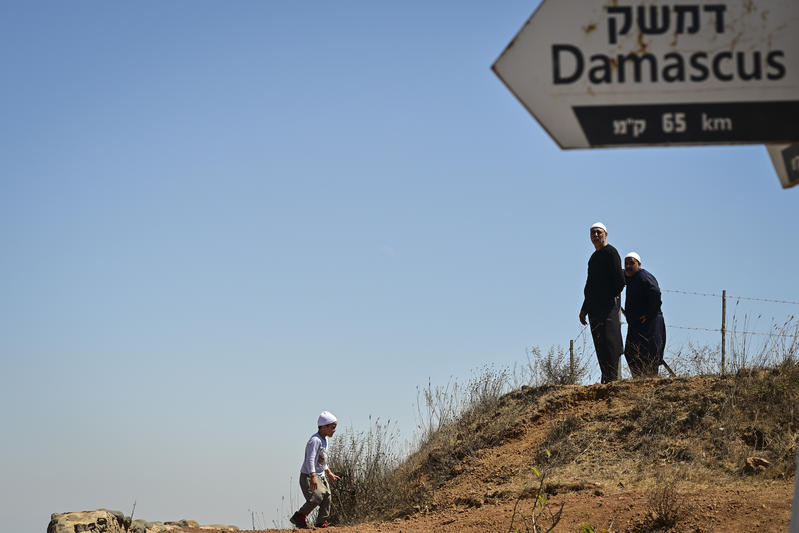 People look at the view on Mount Bental, overlooking the border with Syria, in the Golan Heights