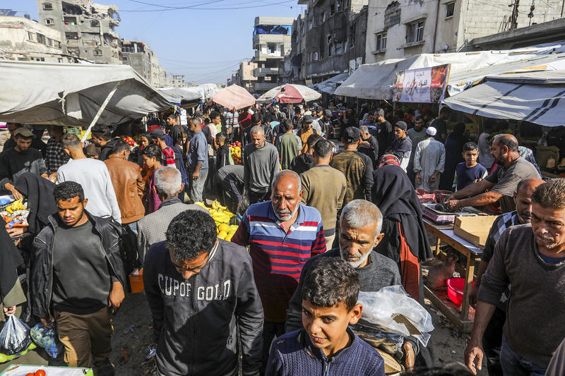 Palestinians shop at a market in Khan Yunis