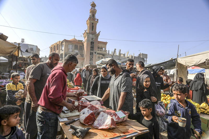 Palestinians shop at a market in Khan Yunis, in the southern Gaza Strip