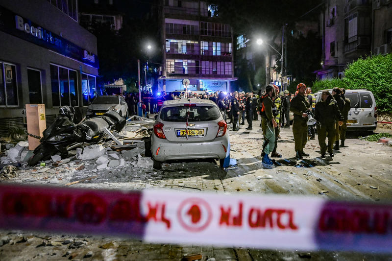 Israeli security and rescue forces inspect the damage at the scene where a missile fired from Iran toward Israel caused damage and killed two people in Ramat Gan, central Israel, March 18, 2026.