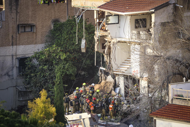 Israeli rescue forces search the scene where a missile fired from Iran struck a building in Haifa, northern Israel, causing extensive damage, April 6, 2026.