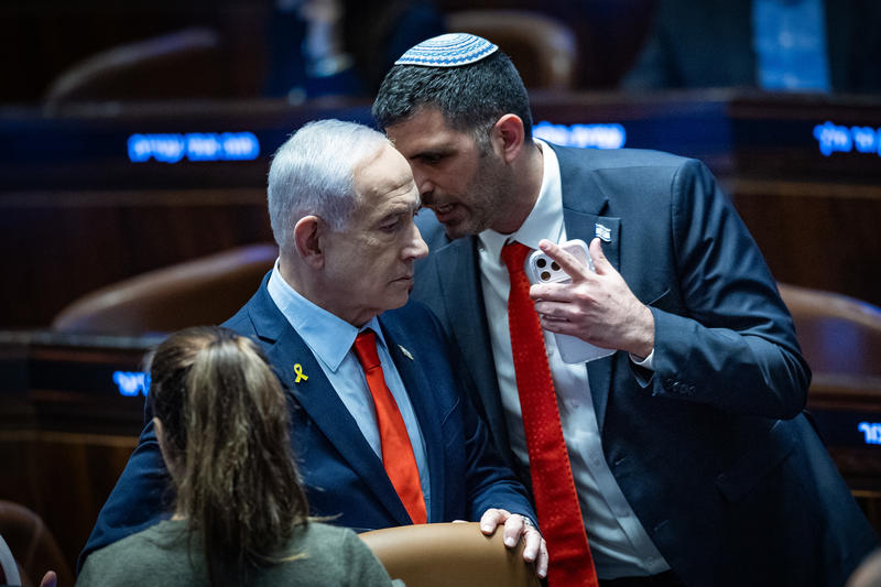 Israeli Prime Minister Benjamin Netanyahu speaks with Minister of Communications Shlomo Karhi during a 40 signatures debate, at the plenum hall of the Knesset, the Israeli parliament in Jerusalem, on January 5, 2026.