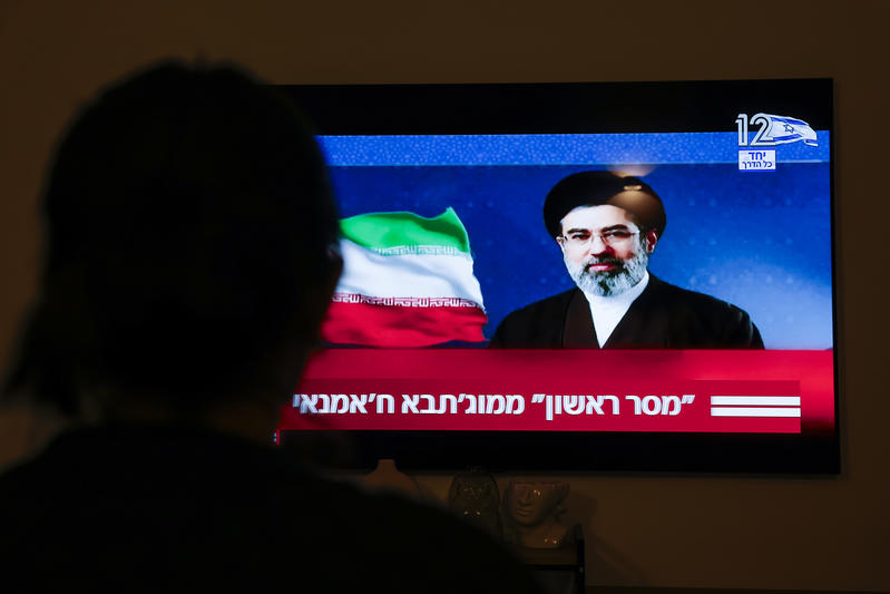 A person watches a television broadcast showing a message from Iran’s Supreme Leader Mojtaba Khamenei to the international community, in Moshav Mishmar David, March 12, 2026.